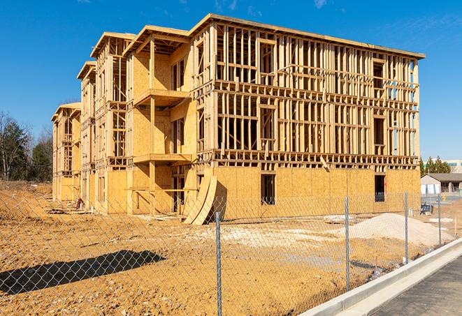 workers protected by temporary barrier fence during building maintenance in Rialto, CA